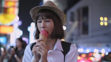 4k Kararlılığın Turizm konsepti. Asyalı kadın şehirde dondurma yemekten zevk alıyor..