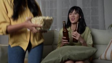 Tatil konsepti 4k Çözünürlük. Evde birlikte film izleyen Asyalı kadınlar. Eğlenceli ve heyecan verici eğlence aktiviteleri.