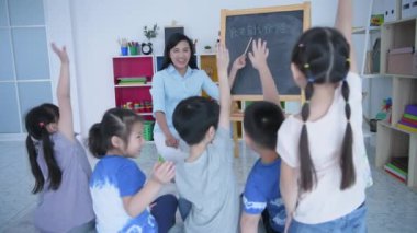 (Chinese wording translation:self introduction) Educational concept of 4k Resolution. The teacher is teaching children to learn Chinese in the classroom.