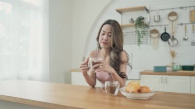 Tatil konsepti 4k Çözünürlük. Asyalı kadınlar mutfakta kahve içiyorlar. Genç kadınların ortak bir lezbiyen ilişkisi var..