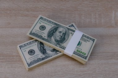 Tahta bir yüzey üzerinde dolar ve para yığını.