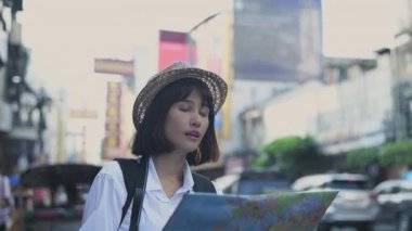 Seyahat konsepti 4k Çözünürlük. Asyalı kadınlar şehirde yer bulmak için haritalar kullanıyorlar..