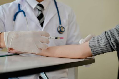 Bir doktor, klinik ortamda bir hastaya aşı uygular, sağlık ve sağlık hizmetlerini ön plana çıkarır..
