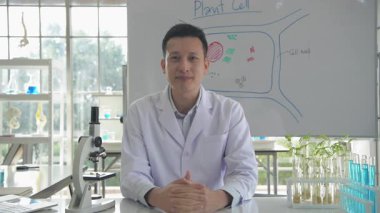 Araştırma konsepti 4K çözünürlüğü. Asyalı erkek bilim adamı laboratuvar iş akışıyla röportaj yapıyor.