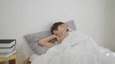 Tatil konsepti 4k Çözünürlük. Asyalı baba hasta oğluna bakıyor. Yatak odasında yatıyor..