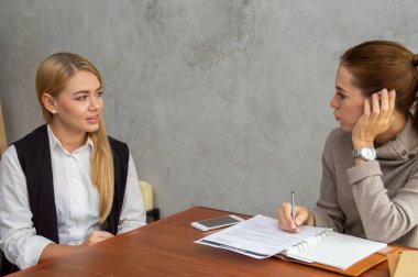 Modern ofis ortamında bir iş görüşmesi sırasında odaklanmış iki kadın..
