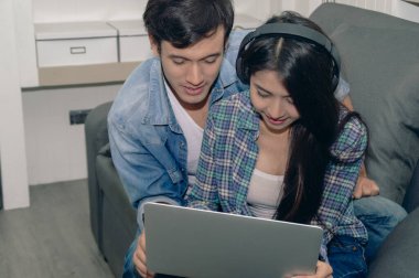 Bir çift dizüstü bilgisayarda bir şey izlerken, samimiyet ve bağlılık göstererek birlikte zaman geçirmekten zevk alır..