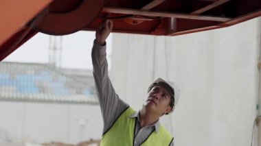 İnşaat konsepti 4K çözünürlük. Mühendis inşaat alanında vinç kamyonunu kontrol ediyor..