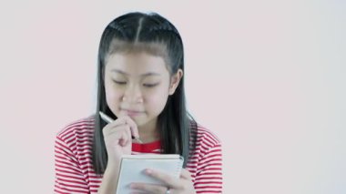 4k çözünürlüğünün eğitici kavramları. Asyalı kız beyaz bir arkaplan üzerine not alıyor..