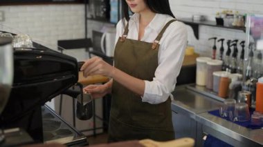 Kafe konsepti 4k Kararlılık. Asyalı kızlar tezgahta kahve yapıyor..