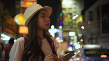 Tatil konsepti 4k Çözünürlük. Geceleri cep telefonu kullanan Asyalı bir kadın..