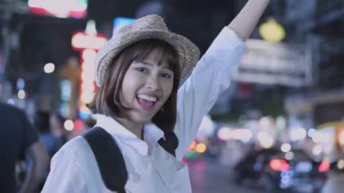 Tatil konsepti 4k Çözünürlük. Asyalı kadın şehirde kameraya el sallayarak dalga geçiyor..