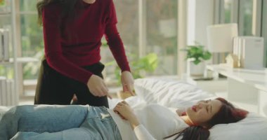 4k Çözünürlük ev arkadaşı konsepti. Asyalı kadınlar yatak odasında birbirlerine sataşıyorlar..