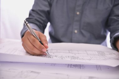 Modern ofis ortamında detaylı planlar üzerinde çalışan profesyonel bir mimar..