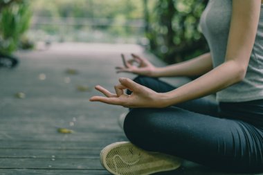 Dışarıda meditasyon yapan bir insan, doğa ile çevrili, huzurlu bir ortamda huzur ve farkındalığı teşvik ediyor..