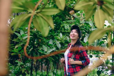 Doğanın ve yeşilliğin tadını çıkaran genç bir kadın güzel bir bahçeyi keşfediyor..