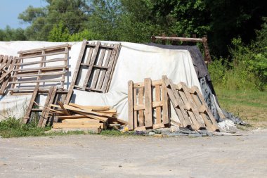 Kırık eski geçici sel koruma duvarı kutu bariyerleri ve kalın jeotextile kumaş ve naylon kaplı kum torbaları aile evlerini büyük sellerden korumak için kullanılan ahşap paletler tarafından bir arada tutuluyor.