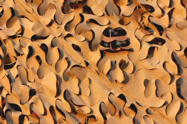 Su geçirmez ultraviyole ışınlar, çöl kamuflajını örten örtünme desenleri, bir tarafta bronzlaşma deseni, diğer tarafta ise yırtılmayı önlemek için güçlü ağlara bağlanmış nesneleri saklamak ve kapatmak için kullanılan yırtık durdurma malzemesinden yapılmış açık ten bronzlaşma.