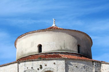 Tarihi yuvarlak taş kulede yıpranmış bir terakotta fayanslı kubbe, küçük kemerli pencereler ve geleneksel Akdeniz mimari mirası sergilenen nihai bir duvar ustası yer alıyor.