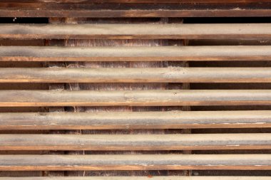 Eski bir ahşap havalandırma ızgarasının yakın görüntüsünde toz kaplı yatay kirişler, yaşı, ihmalkarlığı ve iç havalandırmada temizlik ve bakım ihtiyacını vurgular.