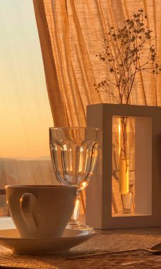 Gün batımının arka planında çay ve fincanlı bir çiçek dalı. Yüksek kalite fotoğraf