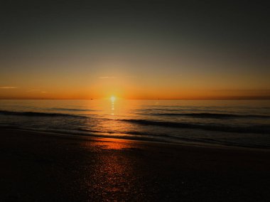 Güney Fransa 'nın Akdeniz kıyısında gün doğumu, düz deniz, Sete yakınlarında küçük dalgalar.