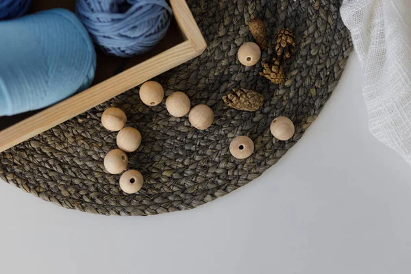 stock image  Wooden necklace, box with blue balls of thread and cones on table. Winter table composition. High quality photo