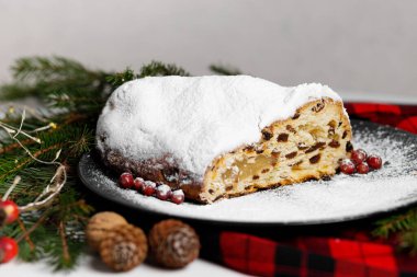  Kırmızı masa örtüsü, çam kozalağı, çelenk ve köknar ağacı dallarıyla süslenmiş siyah tabakta Alman Noel çelenklerini kes. Yüksek kalite fotoğraf