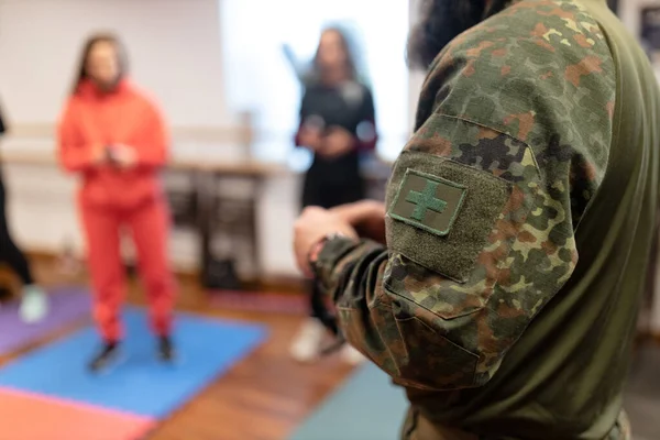 A combat medic conducts tactical medicine classes for civilians. Photo of a doctor on a background of blurred people studying. High quality photo