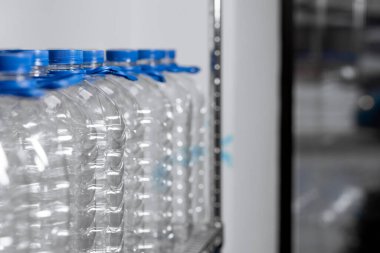 Blue empty water bottles on a shelf in a store. Place for text. High quality photo