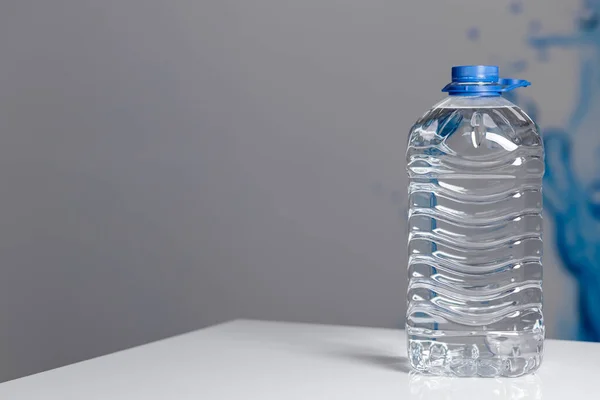 plastic water bottle on the wooden table, sunny day. High quality photo
