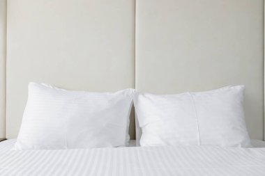 Tarafsız bir arkaplanda beyaz yatak odası olan minimalist parlak bir yatak odası. Oda, modern iç tasarım kavramları için mükemmel, temiz çizgiler ve sakin bir ortam içeriyor..