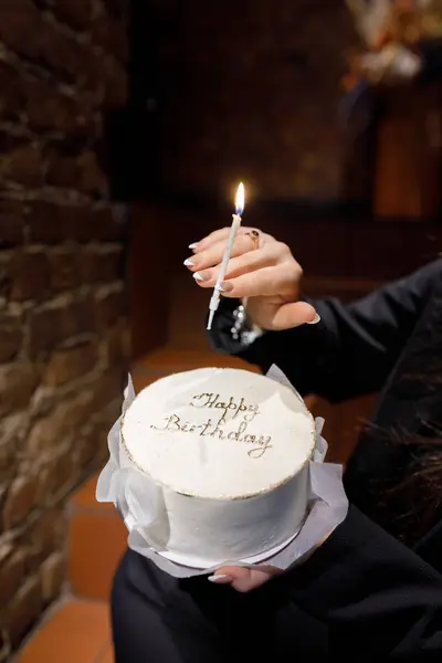 一个女人拿着一个装饰精美的生日蛋糕 上面写着生日快乐 点着一支蜡烛庆祝这个特殊的日子 — 图库照片