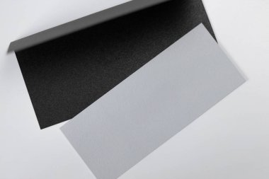 Siyah desenli kağıt levha ile sanatsal olarak düzenlenmiş pürüzsüz beyaz tabaka arasındaki kontrastı gösteren yakın plan bir resim..