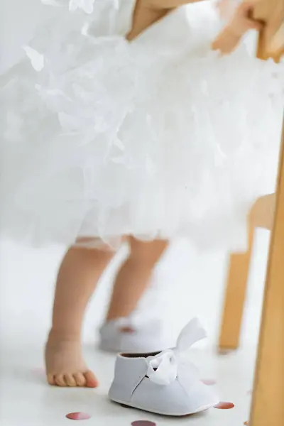 Ein Kind Einem Flauschigen Weißen Kleid Steht Barfuß Neben Einem Stockfoto