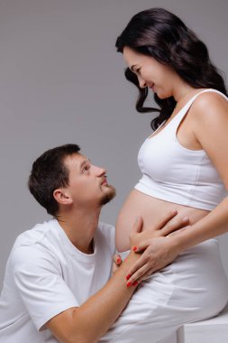 Bir adam partnerine sevgiyle bakar. Bebek çarpması, hassas bir anı paylaşır. Bu güzel sahne, ilerideki yolculukları için heyecanlarını yakalar, aşkı ve beklentiyi ön plana çıkarır..