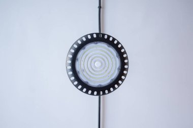 Çembersel bir LED lamba armatürü, şeffaf merkezi ve siyah kenarlı modern bir tasarıma sahip zarif bir şekilde asılır. Basitlik, çevrenin minimalist estetiğini arttırır..
