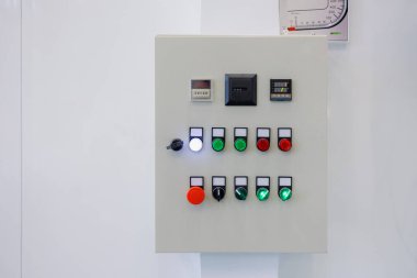 Çeşitli düğmeler, ışıklar ve göstergelerden oluşan bir kontrol paneli ticari bir tesisin duvarına monte edilmiştir..