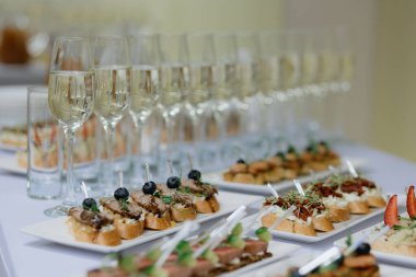 Şampanyalı kanepeler, böğürtlenler ve mikro yeşillikler üzerine seçici bir odak noktası..