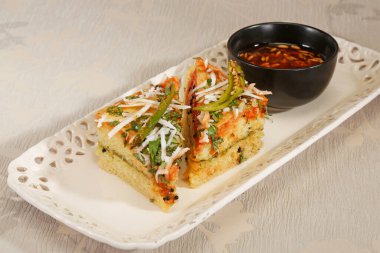 Zirvesinde susam tohumları ve yeşil biberli Hint yemeği var.