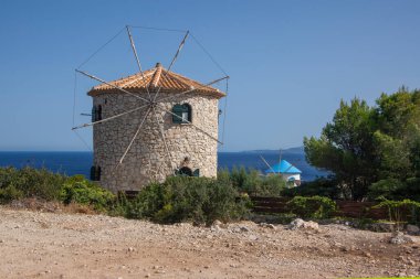 Windmill, Cape Skinari, Zakynthos - 27 Eylül 2021: Kayanın yukarısındaki güzel geleneksel Yunan yel değirmeni