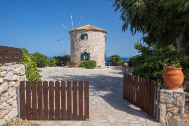 Windmill, Cape Skinari, Zakynthos - 27 Eylül 2021: Kayanın yukarısındaki güzel geleneksel Yunan yel değirmeni