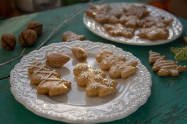 Geleneksel Noel zencefilli çörekleri beyaz tabaklara dizilmiş eski mahsul mahsuller masa, çeşitli Xmas şekilleri ağaçlar, yıldızlar ve kar taneleri.