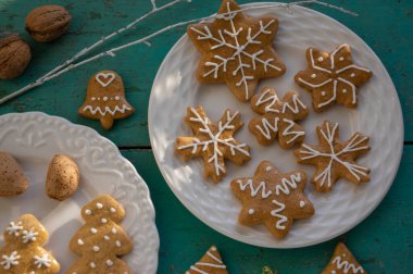 Geleneksel Noel zencefilli çörekleri beyaz tabaklara dizilmiş eski mahsul mahsuller masa, çeşitli Xmas şekilleri ağaçlar, yıldızlar ve kar taneleri.