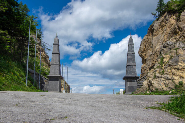 Ljubelj pass in Karawanks chain in Gorenjska region of Slovenia wihh a passageway with two tall stone obelisk on the border between Slovenia and Austria in summer time 