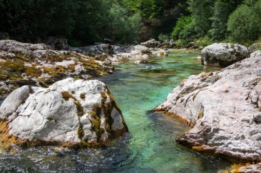 Amazing wild water in mala korita Soce valley, small pure clear turquoise flowing stream through stones gorge