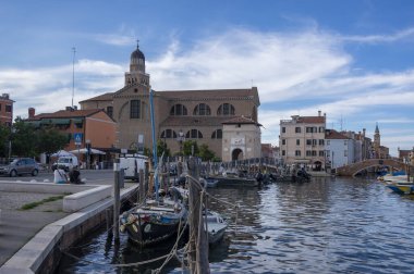 Chioggia, İtalya - 8 Haziran 2022: Su kanalı ve mavi gökyüzünde teknelerle İtalya 'nın Chioggia kasabasında yaşama şekli