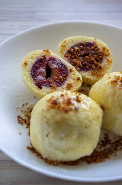 Beyaz tabakta tatlı erikli börek, beyaz şekerli krema ve rendelenmiş zencefilli ekmek, lezzetli czech mutfağı