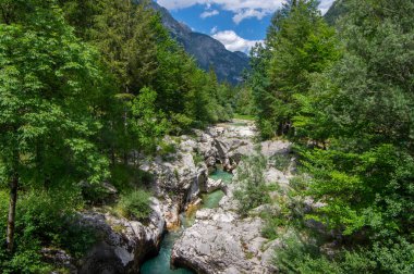 Amazing wild water in mala korita Soce valley, small pure clear turquoise flowing stream through stones gorge