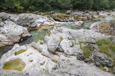 Amazing wild water in mala korita Soce valley, small pure clear turquoise flowing stream through stones gorge